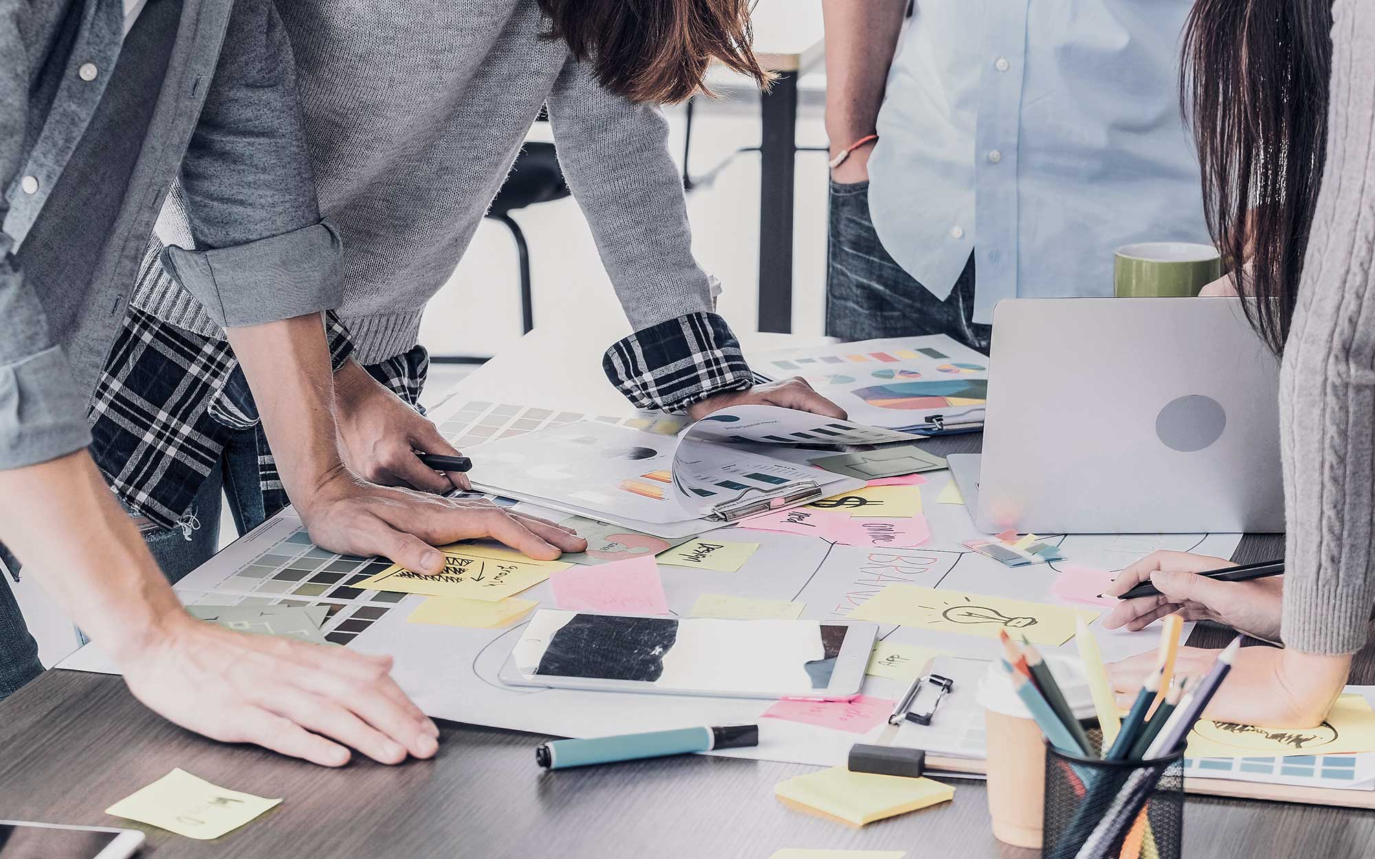 Eine Gruppe von Leuten bespricht an einem Tisch ihre Personal Branding Strategie.