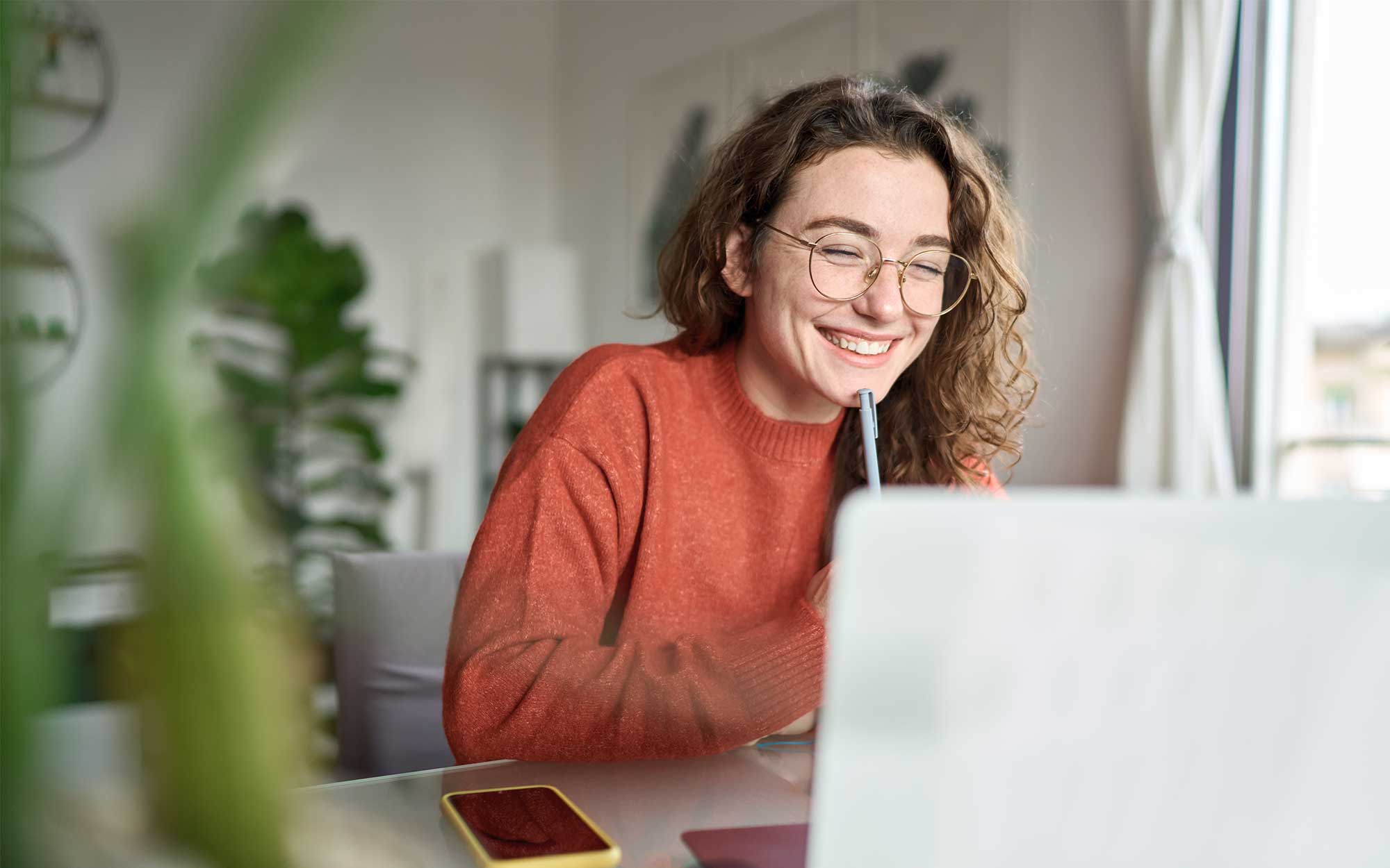 Eine junge Frau bereitet sich am Laptop darauf vor, sich selbstständig zu machen.